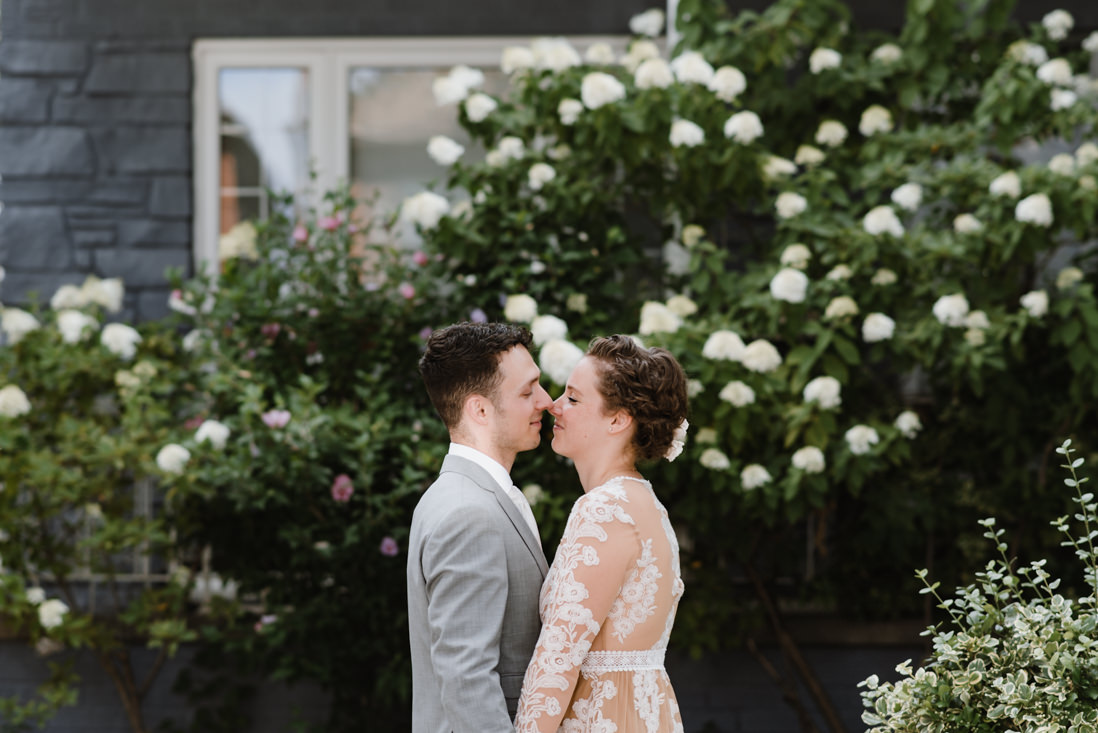 bride and groom in front of hydrangea bush urban Wedding Toronto_EightyFifth Street Photography
