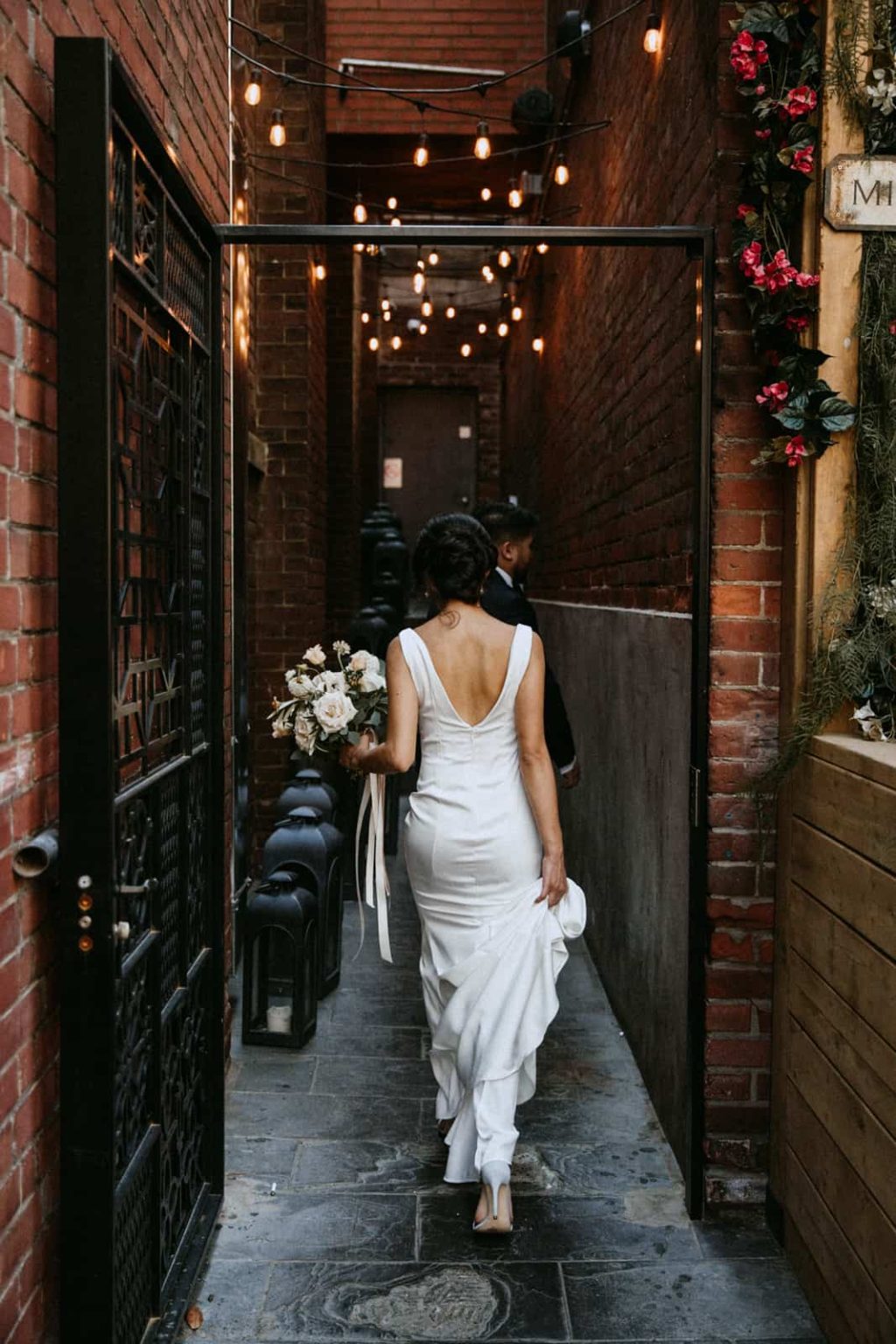 bride walking down toronto alleyway lit with string lights