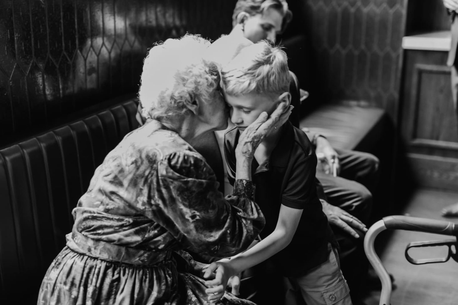 grandma kisses grandchild on cheek at wedding reception